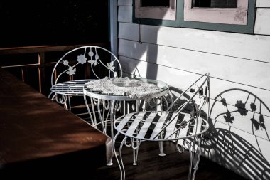 Ön tarafta iki beyaz sandalye.