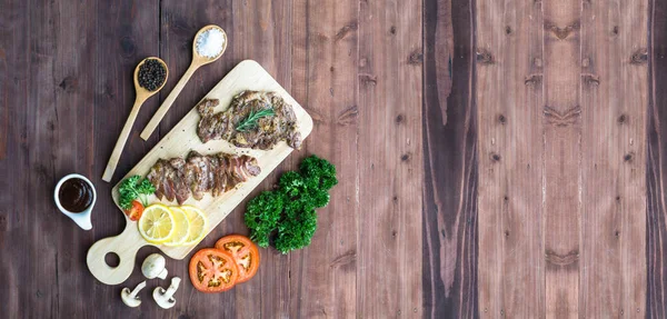 Ahşap kesme tahtasında ızgara biftek. Kopyalama alanı olan üst görünüm