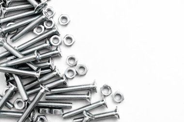 Paslanmaz çelik cıvataların ya da gümüş renkli parlak beyaz arka planda demir çivilerin üst görüntüsü. Metal vidalar metal levhada kullanılır.