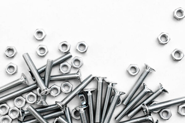 Вид сверху на стальные болты или железные наконечники на ярко-белом фоне с серебристым цветом. Металлические винты для использования в листовом металле
.