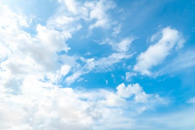 Beyaz kabarık bulutlu mavi yaz gökyüzü. Uçaktaki pencereden çekilmiş bir fotoğraf.