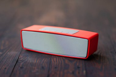 Ahşap zemin üzerinde bluetooth ile kırmızı hoparlörün akustik sesi.