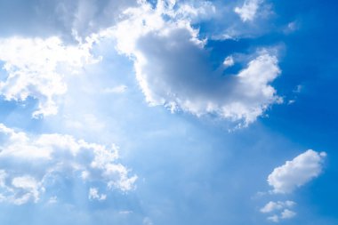 Beyaz kabarık bulutlu mavi yaz gökyüzü. Uçaktaki pencereden çekilmiş bir fotoğraf.