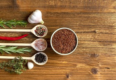 Kahverengi pirinç hazırlamak için malzemelerle ahşap masa manzarası.