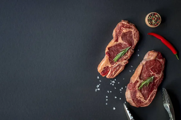 Two Raw Beef Rib Eye Steak On Charcoal Board With Seasonings And Tongs Stock Images Page Everypixel