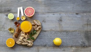 Bağışıklık sistemi güçlendiricisinin üst görüntüsü - zencefil, zerdeçal, portakal suyu, sitruslar, ve eski ahşap masa üzerinde bal