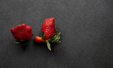 Siyah sedyede çirkin organik çilekler. Üst görünüm, alanı kopyala.