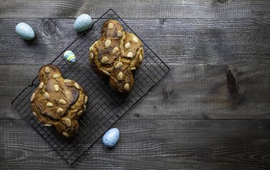 Colomba Pasquale, tipik bir İtalyan Paskalya pastası. Masasında renkli yumurtalar var. Taze pişmiş, üst manzara..