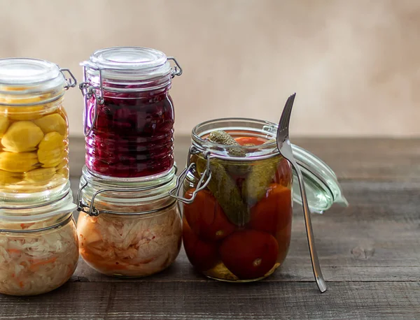 Fermented cabbage, pickled tomatoes, pickled cucumbers, pickled pattypans in glass jars. — Stock Photo, Image