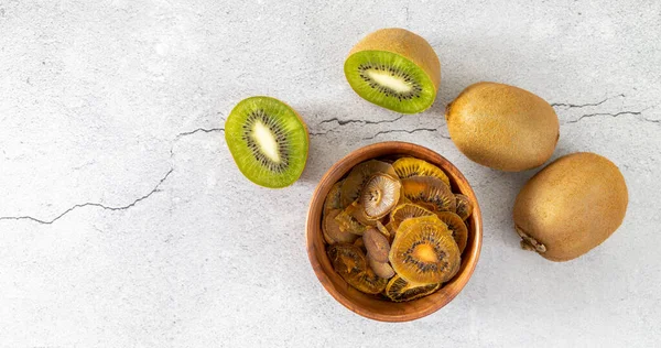 Hemgjorda fruktchips. Torkade skivor av kiwi på en lätt yta — Stockfoto