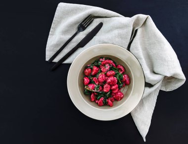 Ispanaklı İtalyan pancar Gnocchi ve siyah çatal bıçaklı peynir sosu. Üst görünüm, alanı kopyala.