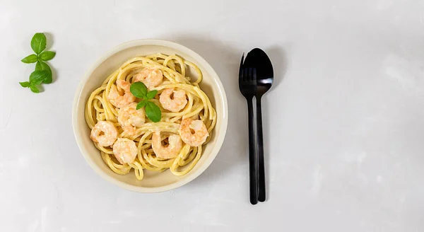 Espaguetis bucatini pasta italiana con salsa de crema de ajo y camarones con cubiertos — Foto de Stock