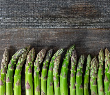 Eski ahşap masada yeşil kuşkonmaz