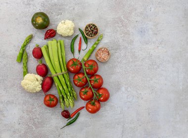 Gri arka planda organik sebzelerle yatıyordu.