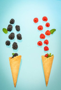 İki dondurmalı waffle külahında düşen böğürtlen. Yaz konsepti