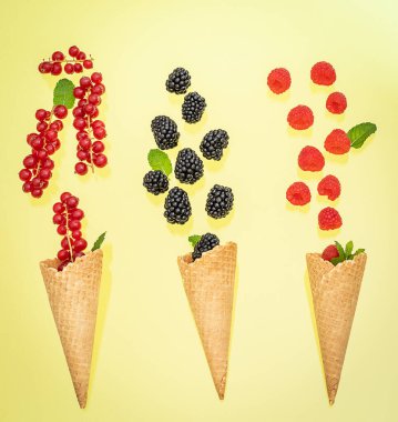 Çeşitli böğürtlenli üç dondurma külahı. Yaz konsepti.