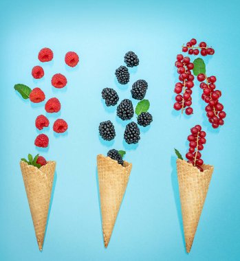 Yaz kavramı. Üç waffle dondurma külahı ve çeşitli meyveler.. 