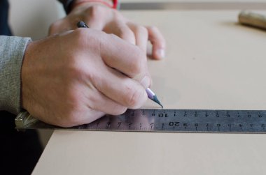 Bir adam marangozluk atölyesinde çalışıyor..