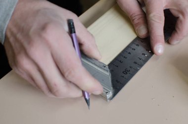 Bir adam marangozluk atölyesinde çalışıyor..