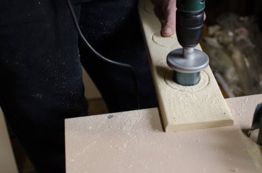 Bir adam marangozluk atölyesinde çalışıyor..