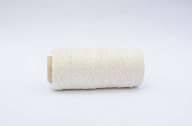 Beyaz pamuklu ip. Beyaz arka planda bir bobin iplik. Yan görüntü. İzole edilmiş beyaz arka plan üzerinde tekstil makarası. Makrome için ip. 