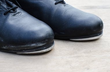 Dans erkek ayakkabıları. Ahşap arka planda geleneksel adım ayakkabıları ve yerde dur..