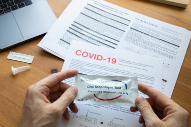Riga, Letonya - 8 Nisan 2020: Coronavirus SARS-CoV-2 evde test ediliyor. COVID-19 Coronavirus için hızlı test kaseti. Hızlı test kiti tutan bir adam. Evde test edin