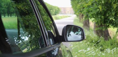 Dikiz aynası kırsalda araba sürüyor.