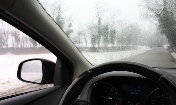 Driving the car on a snowy day - rear view mirror
