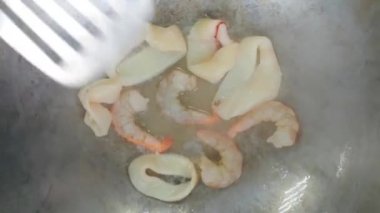 Tavada yağda kızartılmış karides ve kalamar eti.