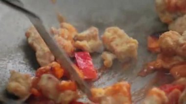 Şef tavada et ve sebze kızartıyor.