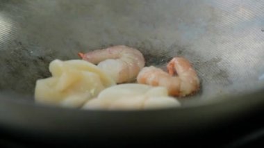 Tavada yağda kızartılmış karides ve kalamar eti.