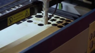 Lazer makinesi ahşap bir yüzeyi oyuyor.