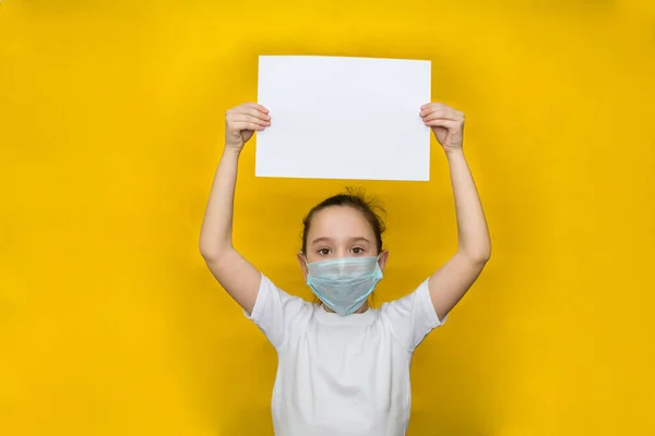 Een Klein Meisje Met Een Beschermend Masker Houdt Een Blanco — Stockfoto