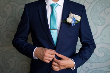 Kravatını bağlayan mavi takım elbiseli bir iş adamı. Güzel gündelik kıyafet. Adam işe hazırlanıyor. Damat ceketini giyer, damat ceketini bağlar, damat sabah, damat masrafları.