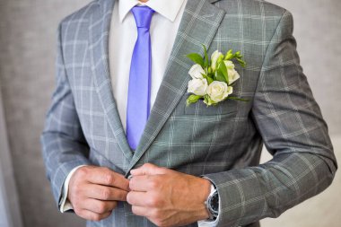 Kravatını bağlayan mavi takım elbiseli bir iş adamı. Güzel gündelik kıyafet. Adam işe hazırlanıyor. Damat ceketini giyer, damat ceketini bağlar, damat sabah, damat masrafları.