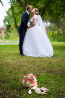 Damat gelin buketin arka planında. Yeni evliler ve düğün buketi. Gelinin buketi.
