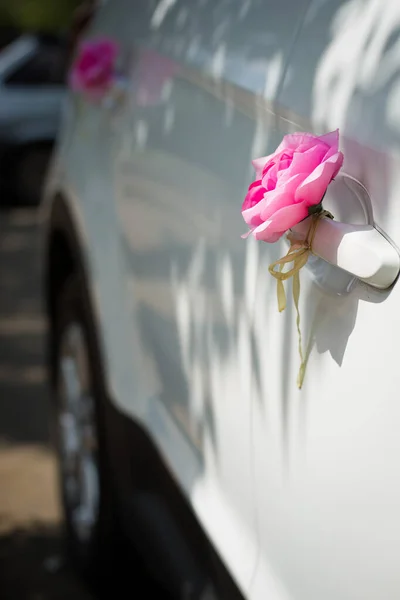 pink roses on the car door. wedding car decorations. wedding procession.