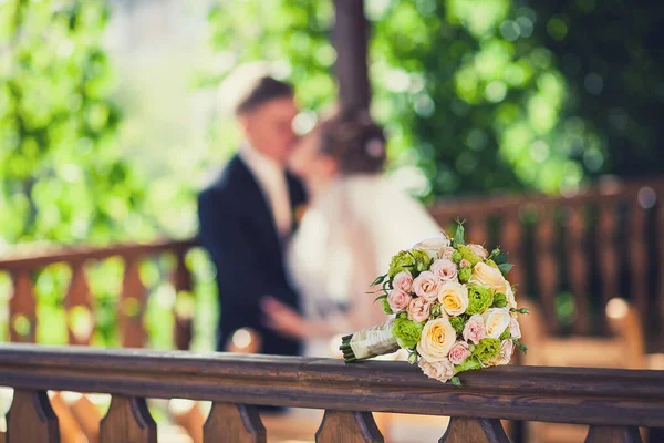 beautiful wedding bouquet on the background of kissing the bride and groom. newlyweds and wedding bouquet.