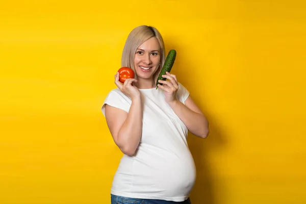 Een Zwangere Vrouw Kiest Tussen Pillen Groenten Een Gele Achtergrond — Stockfoto