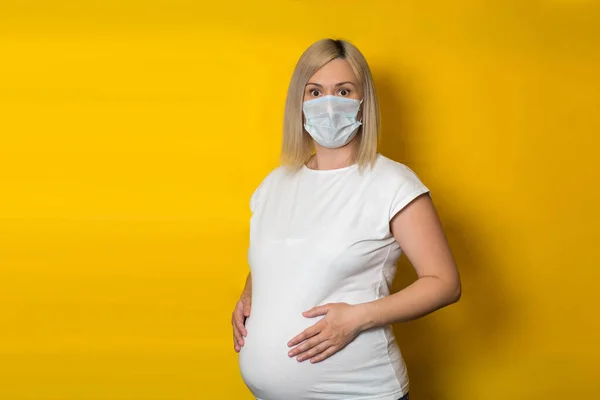 Een Zwanger Meisje Met Een Beschermend Masker Met Verrassende Ogen — Stockfoto