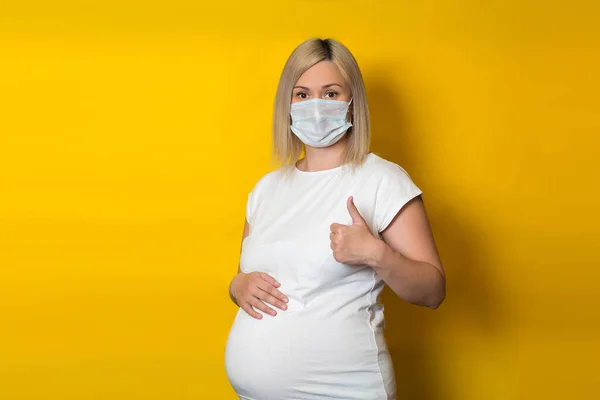 Een Zwanger Meisje Met Een Beschermend Masker Maakt Een Duimgebaar — Stockfoto