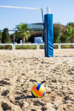 Oyun ızgarasının arka planındaki kumda voleybol renkli top.