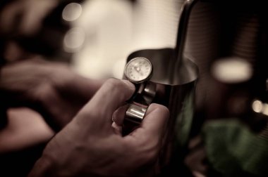 Kahve makinesi buharlı değneği kullanarak sütte süt kaynatan barista.,