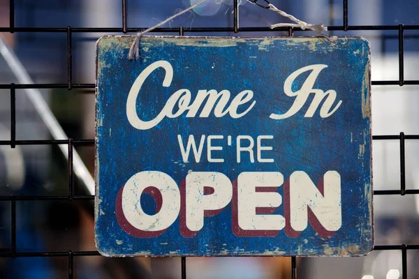 Come In we are open sign hanging on wall Royalty Free Stock Images