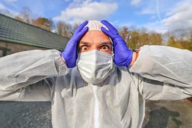 Doctor wearing antiviral protective surgical face mask and coveralls during Coronavirus pandemic worldwide crisis and lockdown in Europe, USA and China. Dangerous SARS-CoV-2 virus Epidemic. clipart