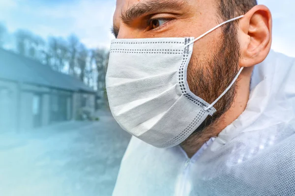 Doctor wearing antiviral protective surgical face mask and coveralls during Coronavirus pandemic worldwide crisis and lockdown in Europe, USA and China. Dangerous SARS-CoV-2 virus Epidemic.