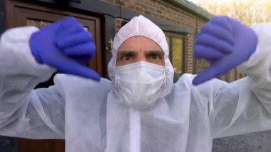Doktor antiviral koruyucu yüz maskesi takıyor ve başparmakları gösteren tulumlar giyiyor. Coronavirus salgını dünya çapında kriz ve Avrupa, ABD ve Çin 'de tecrit. Tehlikeli SARS-CoV-2 virüs salgını.