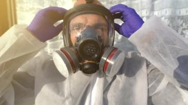 Dünya çapında Coronavirus covid-19 SARS-CoV-2 salgını sırasında tüm solunum maskesi ve beyaz tehlikeli madde örtüsünü çıkaran adam..