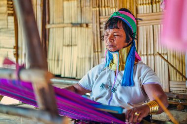 Huay Pu Keng, Tayland - 22 Mart 2019: Kabile köyünde dikiş diken uzun boyunlu Kayan Padaung kadını. Boyunluk takan güzel bir kadın portresi.